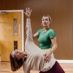 Grace Stilgrove supporting a student through a standing backbend in the Divine Inner Health studio